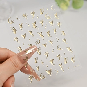 Macro detail of self-adhesive gold nail art decals featuring fairy moon and star designs