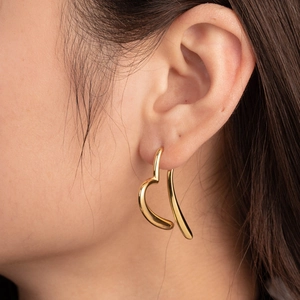 Irregular heart shaped titanium steel earrings in gold finish on female model