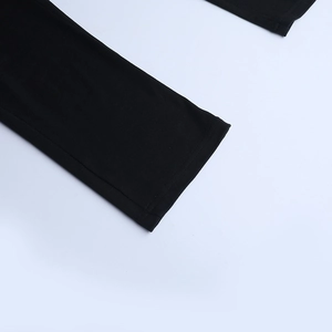 Close-up of fine double-needle stitching on black knitted athletic jumpsuit fabric