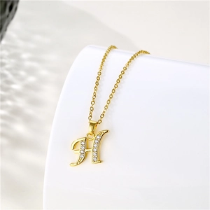 Detail of 18K gold plated necklace with H letter pendant and micro-paved zircons
