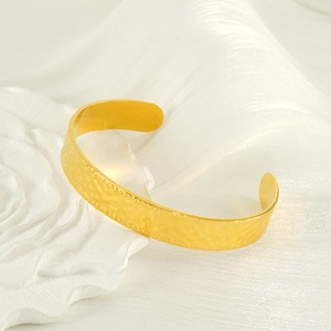Gold-plated C-shaped stainless steel cuff bracelet featuring hammered texture and beaded edges