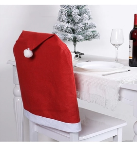 Detail of red Santa hat chair cover with white pompom on a festive dining chair