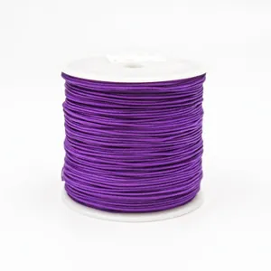Close-up of 0.8mm deep purple braided nylon cord on a white plastic spool for jewelry
