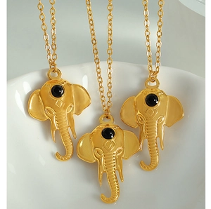 Detailed close-up of gold elephant head pendant necklaces with black stone inlay