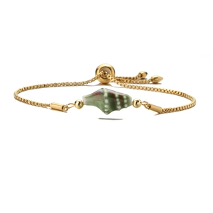 Detail of gold box chain bracelet with green shell charm and adjustable slider bead
