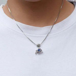 Detailed view of a silver elephant pendant with a blue gemstone on a box chain necklace