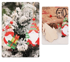 Detail view of wooden Christmas gnome ornaments with red beads on a snowy pine tree