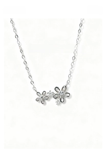 Detailed macro view of silver floral pendant with sparkling zircon stones and cross chain
