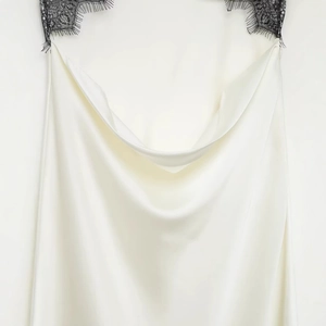 Elegantes elfenbeinfarbenes Satin-Kleid mit V-Ausschnitt und schwarzer Spitze
