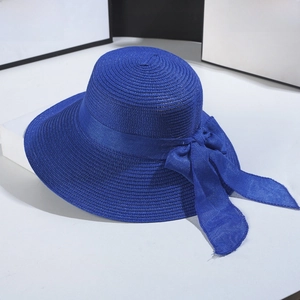 Close-up of royal blue straw sun hat with decorative matching bow ribbon detail