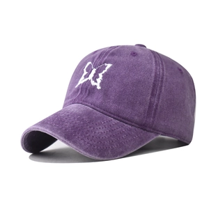 Close-up of embroidered white butterfly on a purple washed cotton baseball cap