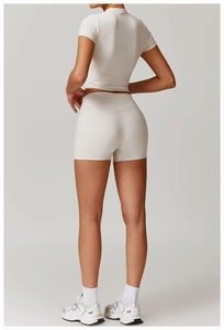 Detail of cream high-waisted yoga shorts and slim-fit tee on a fit model, side view