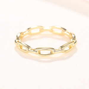Vue macro d'une bague maillon de chaîne dorée polie avec finition miroir sur fond blanc
