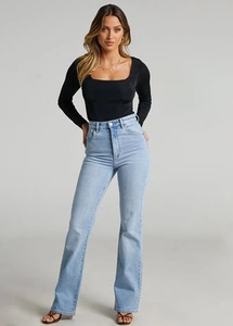 Detail of high-waist flared jeans paired with a square-neck long sleeve top in studio