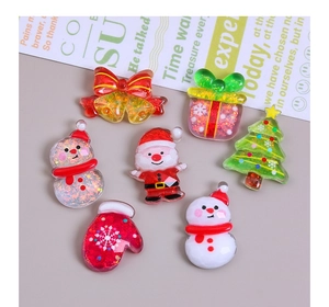 Flat lay of colorful resin Christmas charms including Santa, snowmen, and trees for DIY crafts