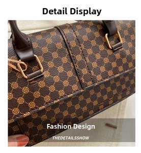Close-up of brown floral printed leather handbag with golden metal rings and fine stitching