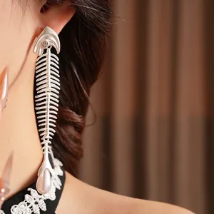 Sliver fishbone earrings with sparkling zircon and white pearl drop on female model
