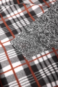 Close-up of ribbed knit cuffs and soft gray texture on a plaid autumn cardigan for men