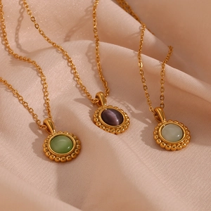 Macro detail of retro sun pendants with olive green, purple and teal stones on silk fabric
