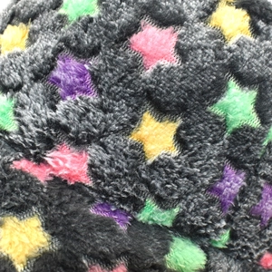 Détail macro du tissu peluche gris foncé épais avec des motifs d'étoiles colorées