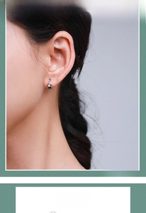 Detail of s925 silver star pendant hoop earring with black and white enamel drip