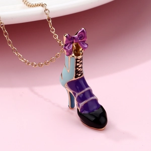 Dettaglio del ciondolo a stivale con fiocco viola su collana dorata