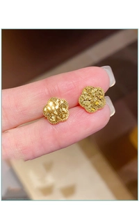 Detailaufnahme goldener Blütenohrringe mit strukturierter, gehämmerter Metalloberfläche