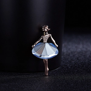 Macro shot of a ballet dancer brooch featuring a light blue crystal skirt and gold metal