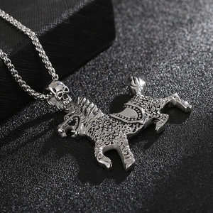 Macro shot of silver titanium pendant with skull clasp and detailed mythical beast scales
