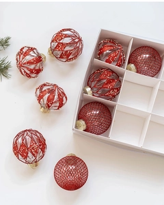 Détail de boules de Noël de 8 cm peintes en rouge et or dans une boîte de rangement