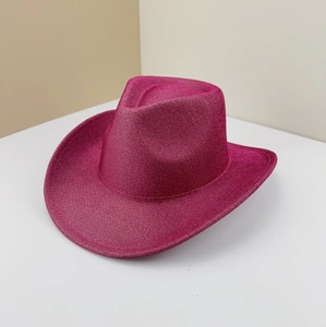 Close-up of pink western cowboy hat with sparkling glitter texture and upturned brim