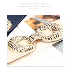 Close-up of decorative gold wave buckles on elastic waist belts in blue and beige