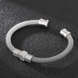 Gros plan d'un bracelet câble en acier inoxydable tressé argenté avec détail hexagonal