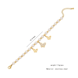Makro-Detail des Edelstahl-Armbands mit weißen Perlen und goldenen Schmetterlingen