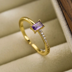 Elegant gold geometric open ring with purple zircon and side diamonds on beige velvet