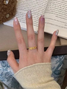 Detail of 24k gold plated ring featuring embossed rose patterns worn by a model