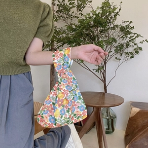 Close-up of small floral cotton wrist bag with vintage flower and fruit patterns