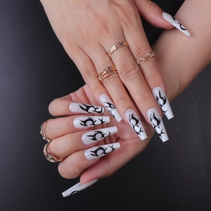 Long coffin-shaped press-on nails with white base and black totem tattoo patterns