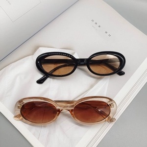 Fashionable oval frame hip-hop sunglasses in black and transparent brown on magazines