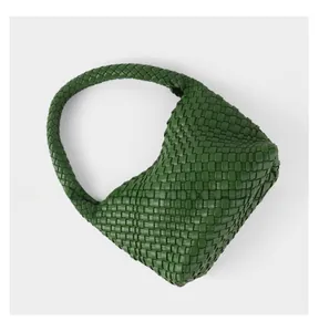 Detailed close-up of dark green hand-woven leather texture on a hobo bag surface