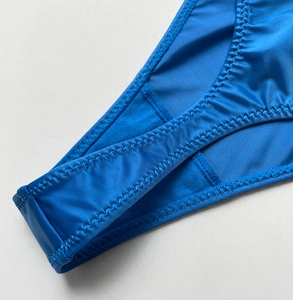 Detailed macro view of the blue high-elastic fabric and zigzag stitching on the thong