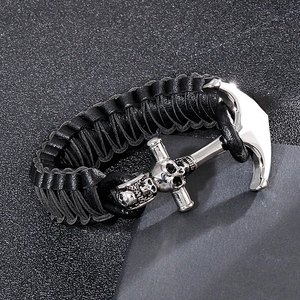 Gros plan du bracelet en cuir tressé avec fermoir ancre argentée et détail de crâne