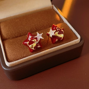 Detailed macro view of red enamel star earrings with gold plating and zircon inlay