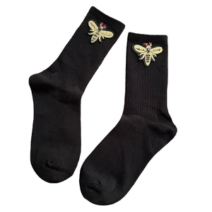 Black crew socks featuring detailed golden bee embroidery with colorful bead accents
