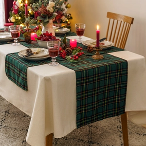 Christmas table runner with green yellow plaid pattern on a beige linen tablecloth