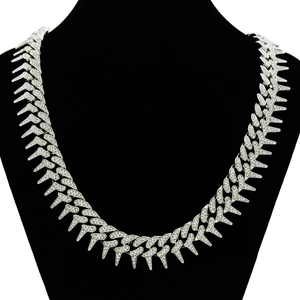 Macro view of silver hip hop Cuban chain necklace with iced-out spiked geometric links