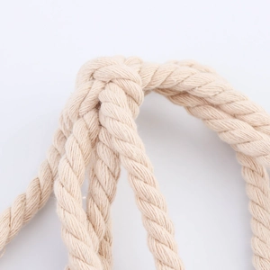 Gros plan sur la poignée en corde tressée beige avec nœud de la robe de plage en lin