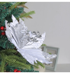 Macro detail of white glitter artificial Christmas flower hanging on green tree branches
