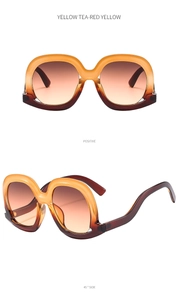 Detail view of big frame sunglasses with yellow and tea-red gradient lenses and frames