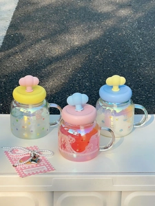 Detailed view of colorful holographic glass mugs with cloud lids and cute printed patterns